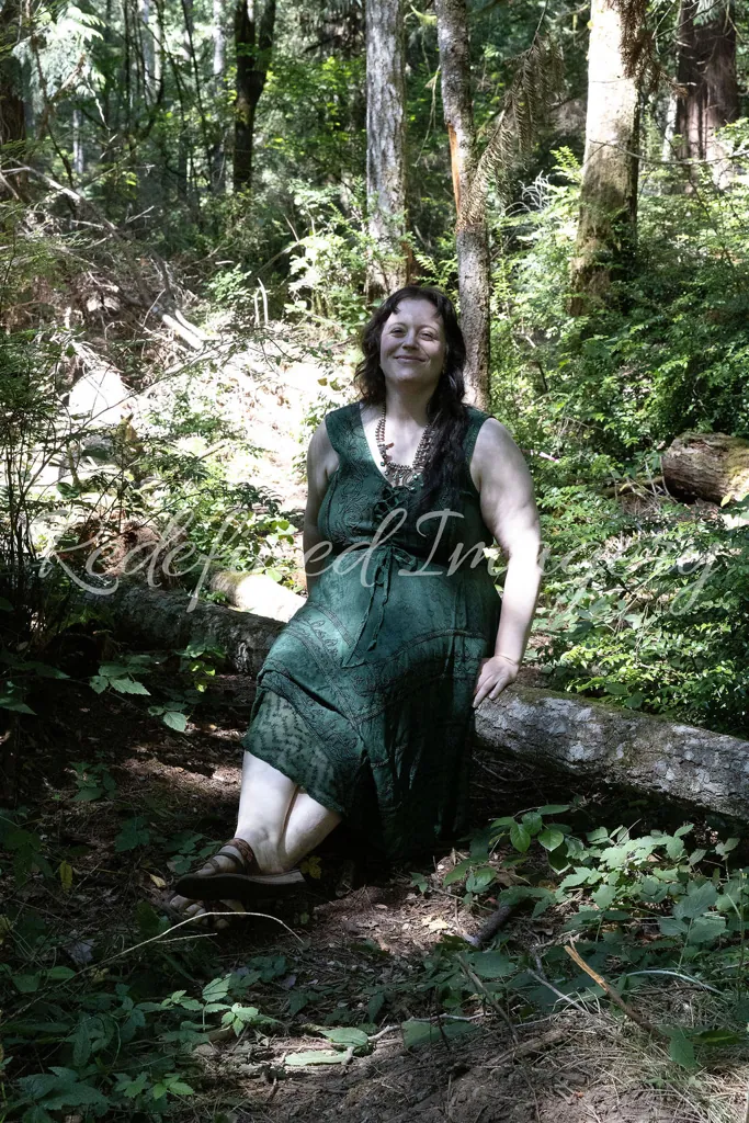 Morgan Nilsen sitting on a fallen log in the forest